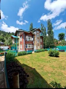 a large brick building with a large yard at Oak Heaven Cottage Gulmarg in Tangmarg