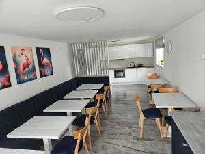 a restaurant with tables and chairs and a kitchen at Dom wakacyjny Welle Dziwnów in Dziwnów