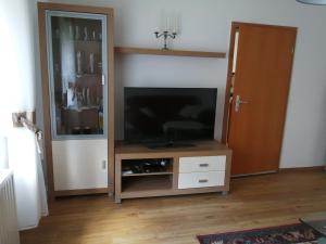 a entertainment center with a flat screen tv in a living room at Ferienwohnung Moni in Kitzscher