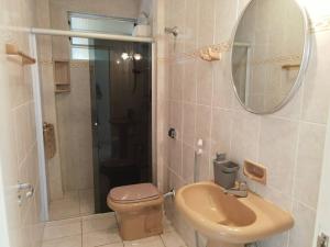 a bathroom with a toilet and a sink and a mirror at Ap com sacada à beira mar Praia mansa in Matinhos +14 photos