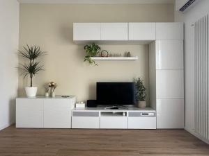 ein Wohnzimmer mit einem TV auf einem weißen Schrank in der Unterkunft Casetta Diana in Lido di Ostia