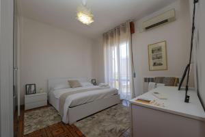 Un dormitorio blanco con una cama y un escritorio. en Modena - vicino al centro - Free Parking & Wi-Fi, en Módena