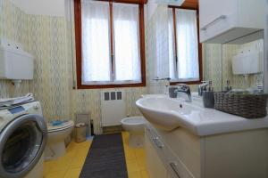 Un baño con lavabo y lavadora. en Modena - vicino al centro - Free Parking & Wi-Fi, en Módena
