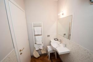 a white bathroom with a sink and a mirror at Florian Rooms Guest House in Rome