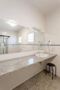 a bathroom with a sink and a large mirror at Sítio da malva in Sorocaba
