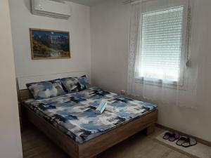 a bed with a dog sitting on it in a bedroom at Apartmani Stojković Vrdnik in Vrdnik