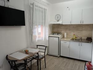 a small kitchen with a table and a sink and a stove at Apartmani Stojković Vrdnik in Vrdnik
