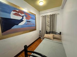 ein Zimmer mit einem Gemälde eines Pfaus an der Wand in der Unterkunft Orsan Apartelle in Pio Duran