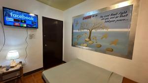 Zimmer mit einem Schild an der Wand und einem Bett in der Unterkunft Orsan Apartelle in Pio Duran