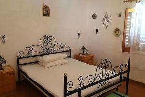 a bedroom with a black bed with white sheets at Appartamento incantevole con piscina condivisa in Falcone