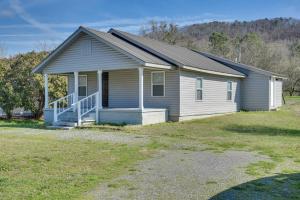 a small house with a porch on a yard at Lake Guntersville Home 1 Mi to Boat Ramp! in Guntersville