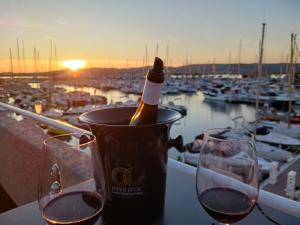 a bottle of wine in a bucket with two glasses at La Paillote in Villeneuve-lès-Maguelonne