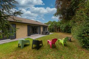 a group of colorful chairs sitting in the yard at Grande Maison Luxueuse - Paris - Villepinte in Villepinte