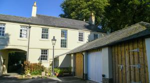 an old white house with a garage and a building at Temple Croft Bed and Breakfast in Alston