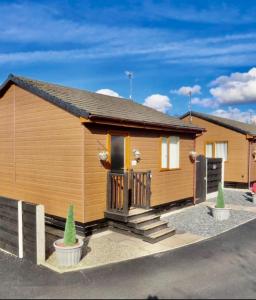 a tiny house with a porch and a driveway at Ivy Cabin with Hot Tub in York