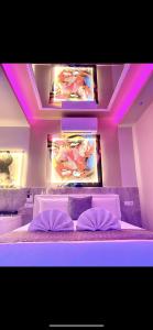 a bedroom with a bed with purple lights on it at Bed Cinecittadue in Rome