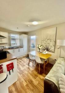 a kitchen and living room with a table and a couch at Ivy Cabin with Hot Tub in York