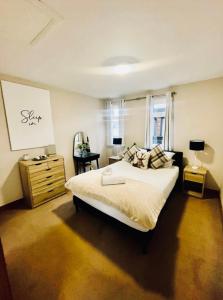a bedroom with a bed and a dresser and a lamp at Ivy Cabin with Hot Tub in York