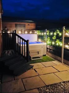 a hot tub on a deck at night with lights at Ivy Cabin with Hot Tub in York +1 photo