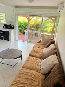a living room with a couch and a table at T2 Proche de la Plage du Souffleur - Villa Minerva in Port-Louis +8 photos