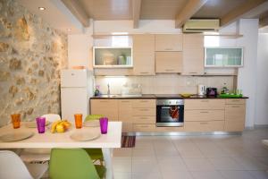 a kitchen with a white table and green chairs at AC Homes Christos in Rethymno Town