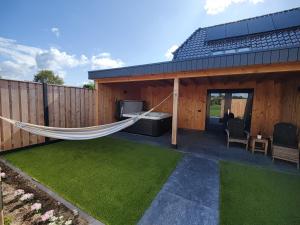 a hammock on the back of a house at B&B de Gouden Ploeg met Jacuzzi in Bergentheim