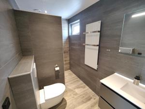 a bathroom with a toilet and a sink at B&B de Gouden Ploeg met Jacuzzi in Bergentheim