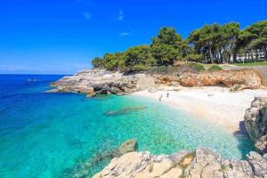 a beach with a group of people in the water at Center Apartments BAG, With PRIVATE FREE PARKING in Pula
