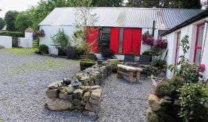a garden with a bench in front of a building at Stone Wall Cottage in Castlewellan +8 photos