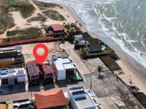 una vista aerea di una spiaggia con marcatore rosso di Casa Gostoso Mar - Apartamentos a São Miguel do Gostoso