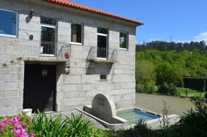 a stone house with a pool in front of it at Rilhadas Casas de Campo in Fafe