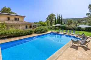 a swimming pool with chairs and a house at VILLA JACELIA in Sa Pobla