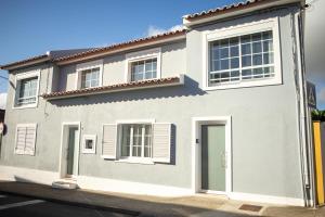 a white house with a green door on a street at Casa do Troféu in Relva