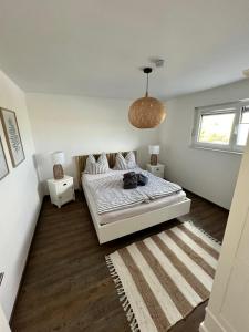 una camera bianca con un letto e un tappeto di Ferienresort - idyllisches Ferienhaus mit Privatstrand und Sauna in der Nähe von Leipzig #HausJonas a Löbnitz