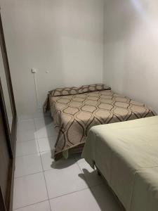 a bedroom with two beds and a tiled floor at Loft no centro de Araxá in Araxá +10 photos