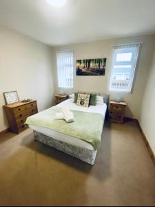 a bedroom with a large bed and two windows at Tulip Cabin with Hot Tub in York
