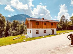 a house on a hill next to a road at Das Waschhaus in Ruhpolding +3 photos
