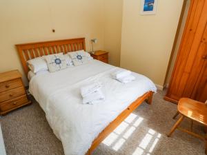 une chambre avec un lit avec des serviettes dessus dans l'établissement Brick Cottage, à Helston