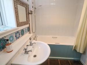 une salle de bain avec un lavabo et une baignoire dans l'établissement Brick Cottage, à Helston 19 autres photos