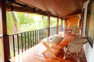 a porch with a wooden table and chairs on it at Marari Xavier's Inn in Alleppey