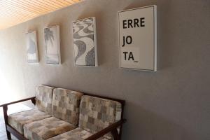 a living room with a couch and pictures on the wall at HOSTEL ErreJota in Jaguariúna