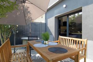 a wooden table with a potted plant on a patio at La maison du Stadium in Brive-la-Gaillarde
