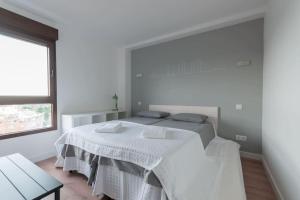 una habitación blanca con una cama y una mesa en ºººCH Residential Area Modern City Views WiFi ACººº, en Madrid