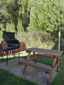 een picknicktafel, een grill en een picknickbank bij Alentue in Dina Huapi