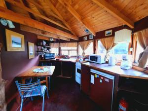 een kleine keuken met een tafel en een aanrechtblad bij Alentue in Dina Huapi