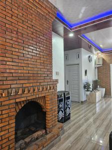 ceglany kominek na środku salonu w obiekcie Villa Nauli w mieście Bandarbaru