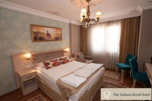 イスタンブールにあるスルタン ロイヤル ホテルのベッドとシャンデリアが備わるホテルルームです。