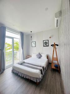 a bedroom with a large bed and a large window at Sele House in Ha Tien +152 photos