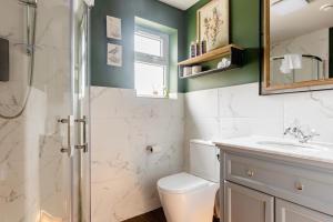 a bathroom with a shower and a toilet and a sink at Stunning Private en-suite studio in Cobham in Cobham
