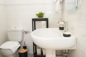 a white bathroom with a toilet and a sink at Kalamata 360 View in Kalamata +19 photos